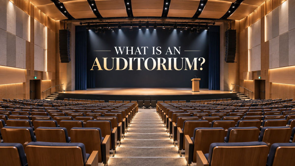 Modern auditorium with raked seating, central stage, acoustic panels, and clear audience sightlines.