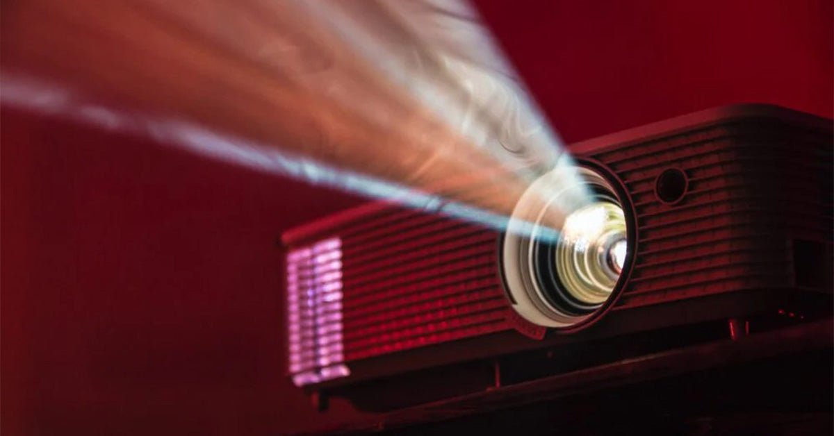 Home theater projector beam shining in a dark red room