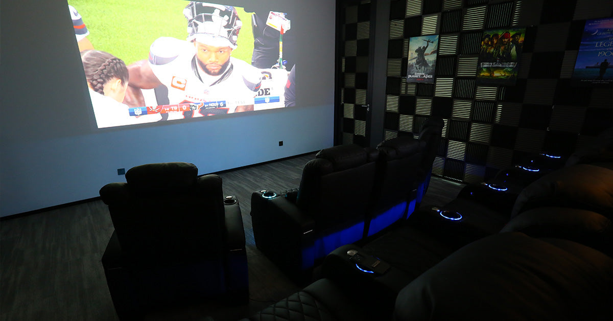 Home theater setup with projector screen leather recliners and LED aisle lighting