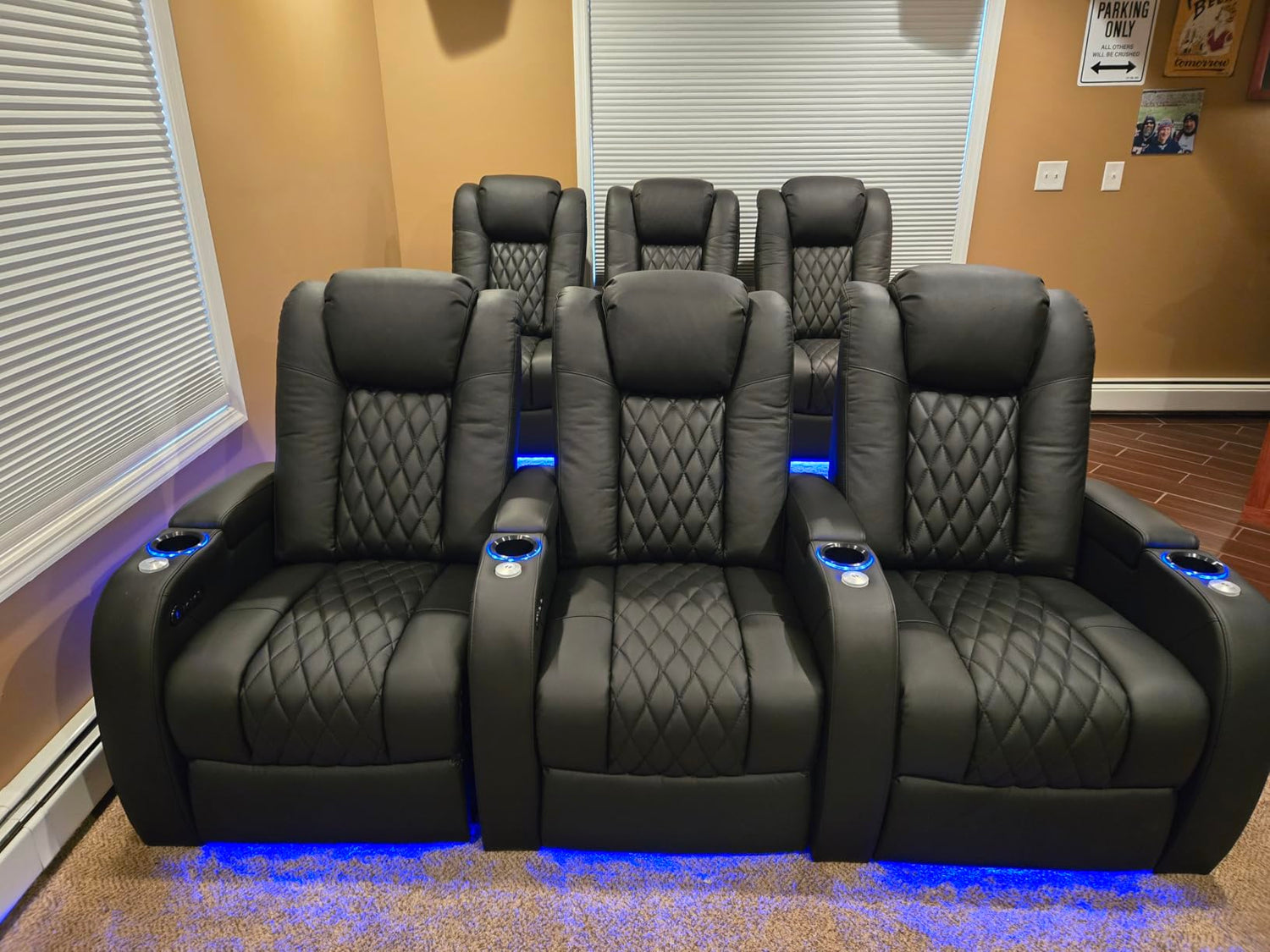 Front row of black home theater recliners with blue LED base lighting
