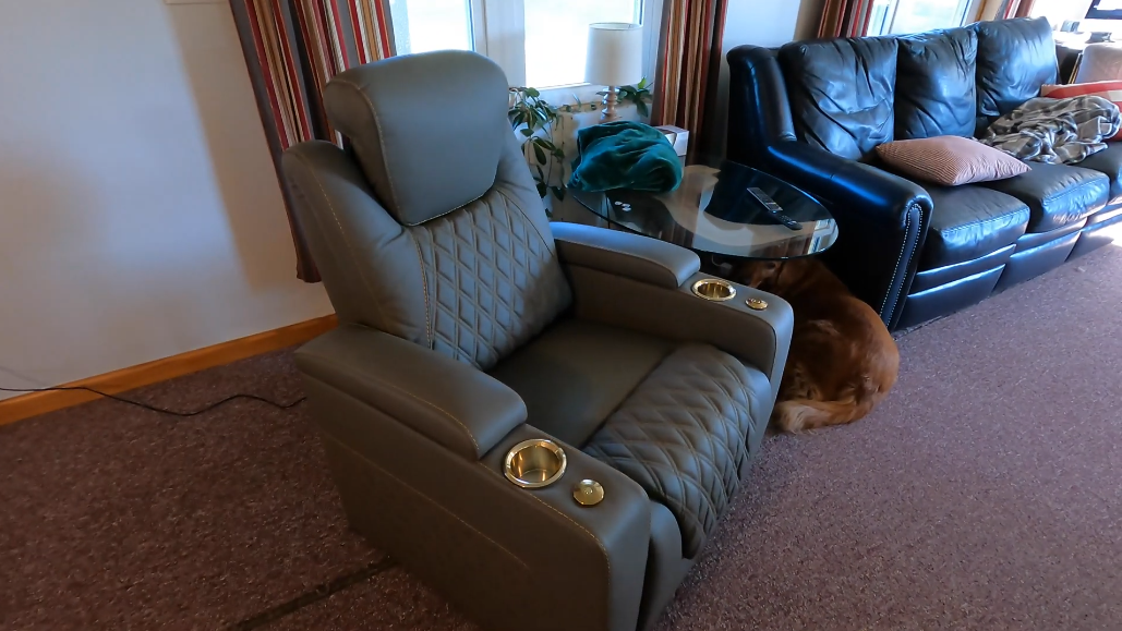 Gray home theater recliner with quilted leather and gold LED cup holders in living room