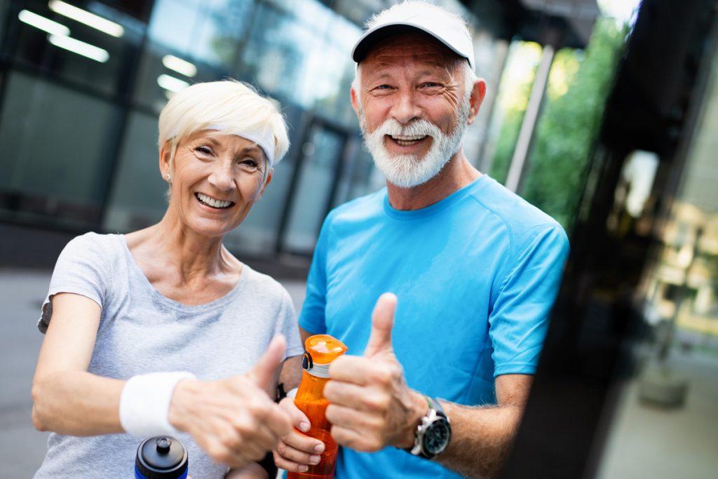 Active seniors giving thumbs up after outdoor workout