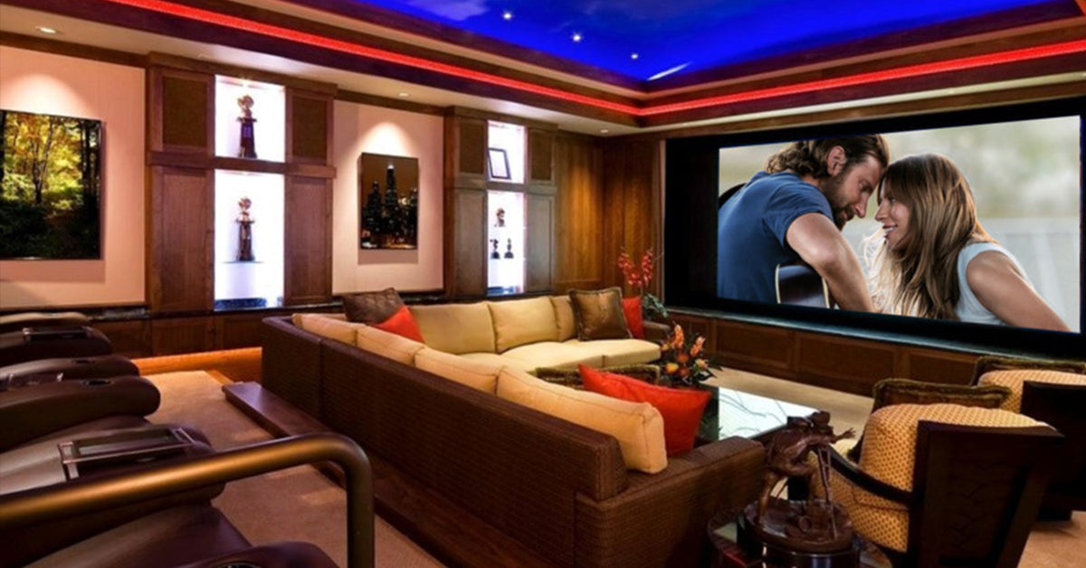 Luxury home theater with large screen, sectional sofa, LED ceiling lighting, and wood panel walls.
