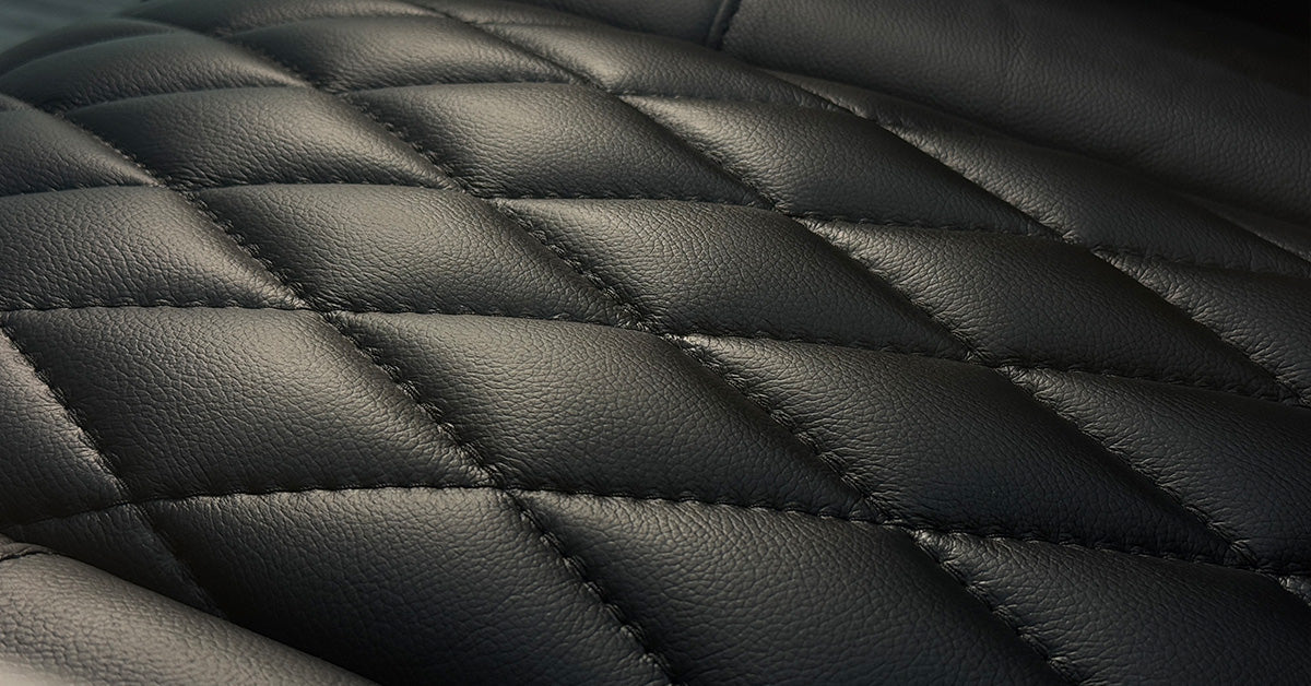 Black quilted leather upholstery texture, close‑up