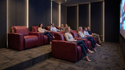 Premium zero clearance home theater recliners installed completely flush against a dark acoustic wall panel