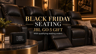 JBL Go 5 on a side table beside black leather theater recliners for a Black Friday seating gift promotion