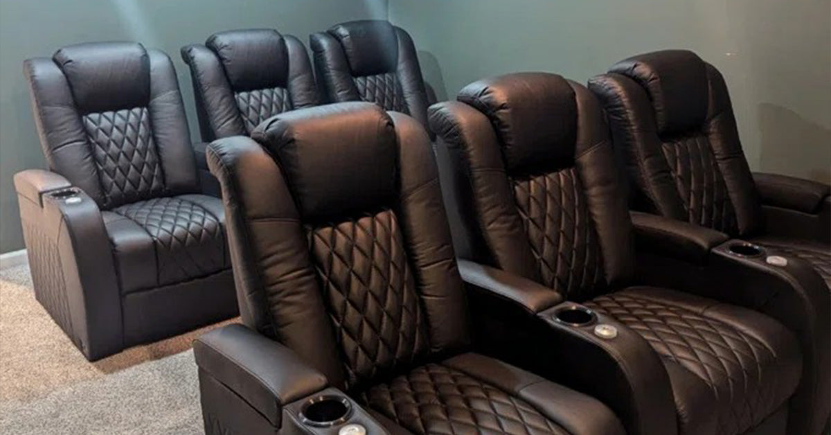 A home theater with plush leather reclining seats and a large projection screen, creating a premium entertainment experience.
