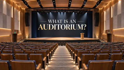 Modern auditorium with raked seating, central stage, acoustic panels, and clear audience sightlines.