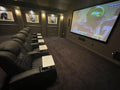 Luxury home theater with black leather seating and game day viewing