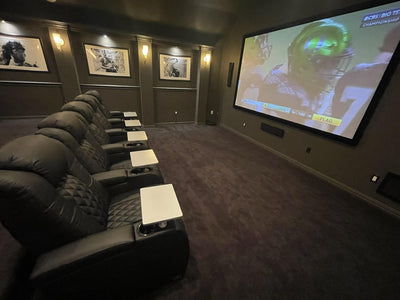 Luxury home theater with black leather seating and game day viewing