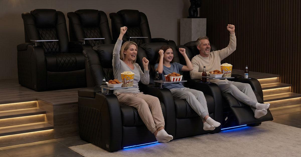 Family cheering in home theater recliners with snacks