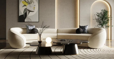 A modern living room with a stylish, curved sofa, decorative pillows, and a minimalist coffee table.