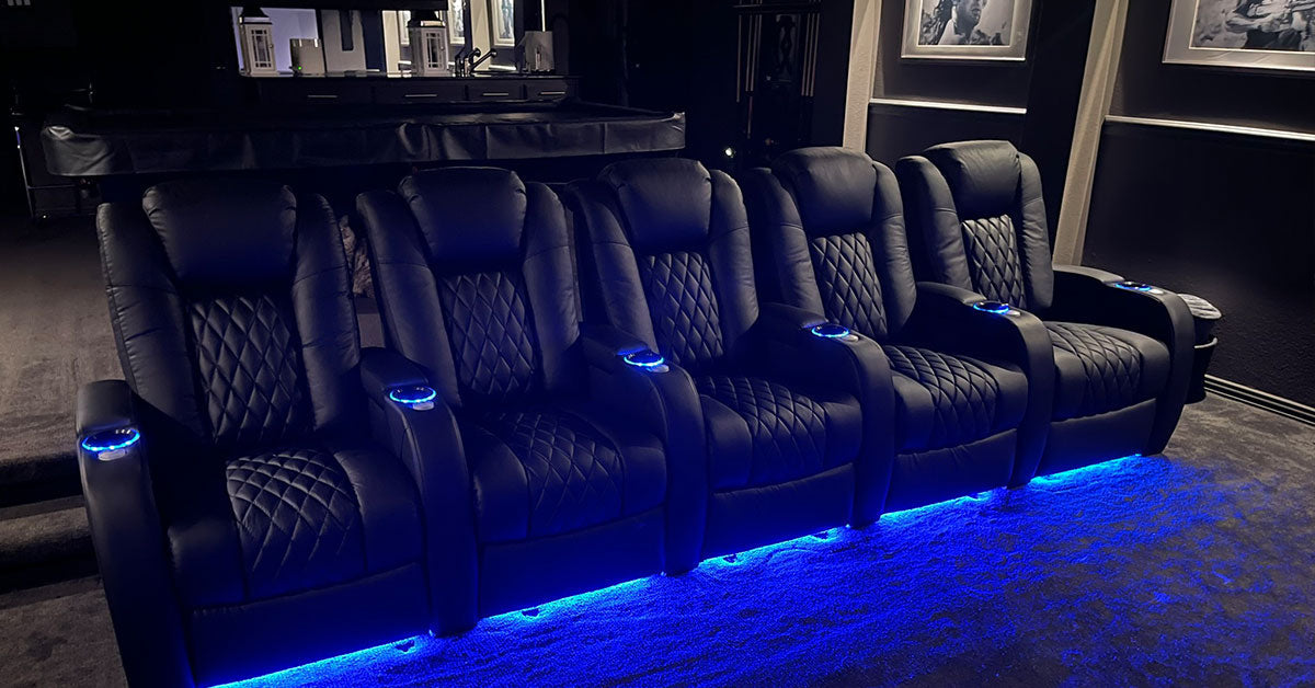 Luxury home theater recliners with blue LED lighting in a dark cinema room