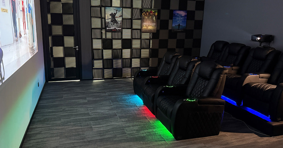 Home theater seats with RGB ambient lighting facing a projector screen.