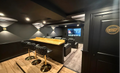 Basement home theater entrance view with bar top, recliner seating, and Dolby Atmos sign
