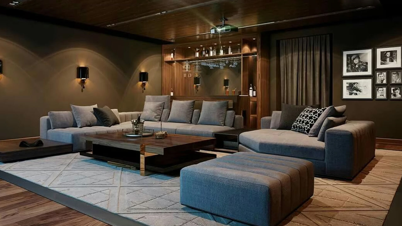 A sophisticated living room or home theater space with a large sectional sofa, warm ambient lighting, and a stylish bar area in the background.