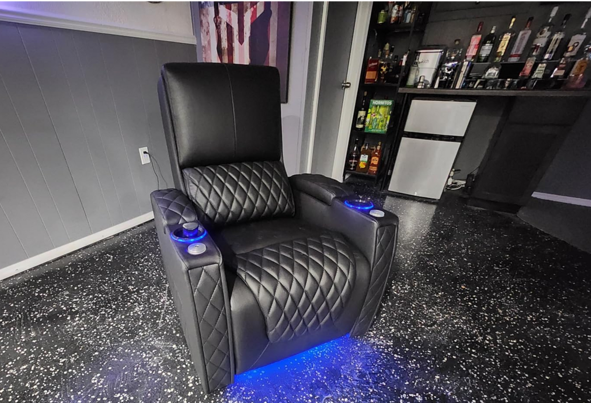Luxury home theater recliner with cup holders and blue LED lights in a bar room