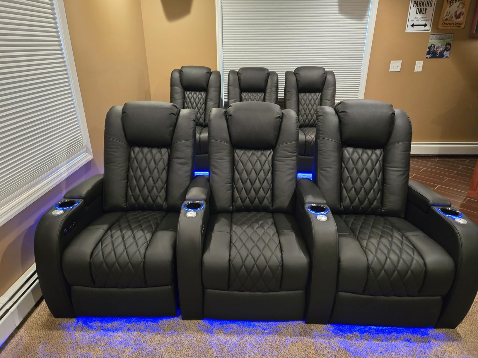 Front row of black home theater recliners with blue LED base lighting