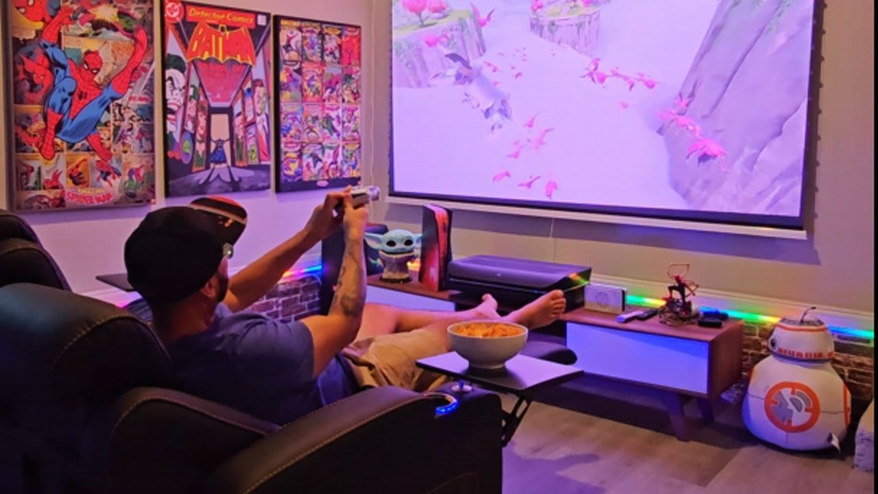 The image shows a person, likely a young man, sitting in a gaming setup in what appears to be a home environment. 