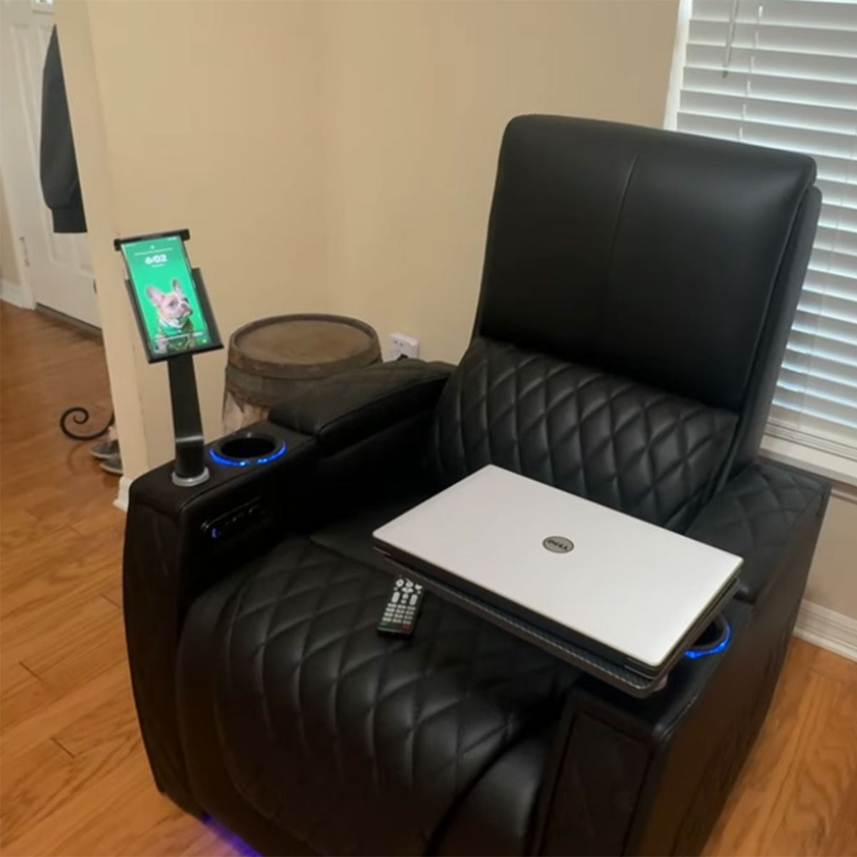 A recliner with a tablet holder, laptop, and other items, showcasing the recliner as a multi - functional hub for work and entertainment with the holder.