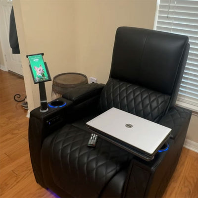 A recliner with a tablet holder, laptop, and other items, showcasing the recliner as a multi - functional hub for work and entertainment with the holder.