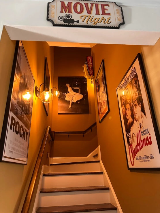 Vintage movie-themed stairway with classic posters and “Movie Night” sign