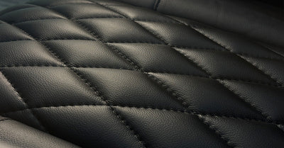 Black quilted leather upholstery texture, close‑up